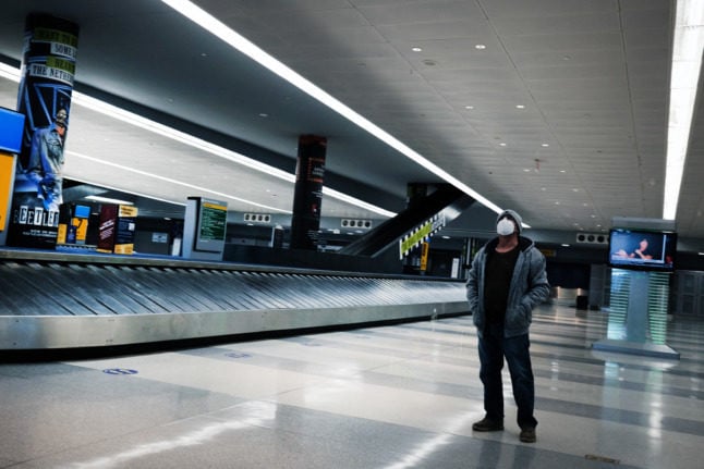 Pictured is somebody in the baggage hall in JFK airport.   