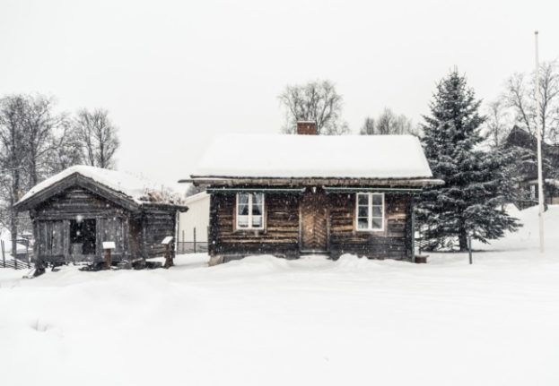 Pictured is a traditional cabin in the snow. 